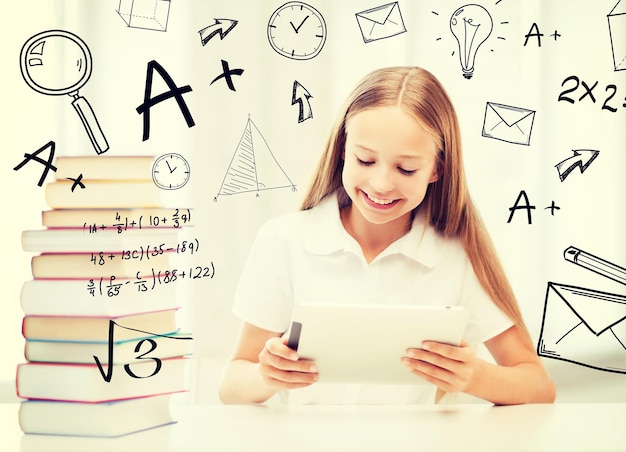 koncepcja edukacji, szkoły, technologii i Internetu - mała studentka z komputerem typu tablet i książkami w szkole