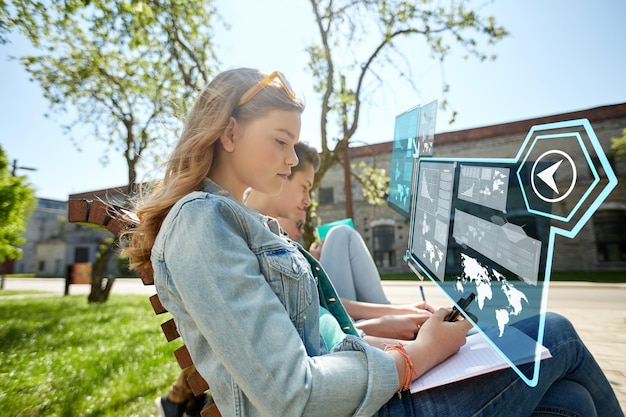 koncepcja edukacji, technologii i ludzi - grupa studentów ze smartfonami i notatnikami na zewnątrz