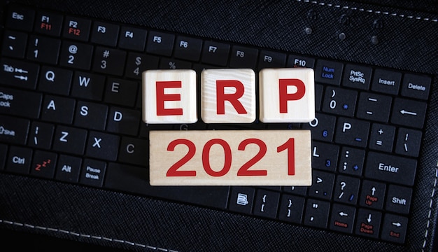 Koncepcja ERP 2021. Drewniane kostki na czarnej klawiaturze.