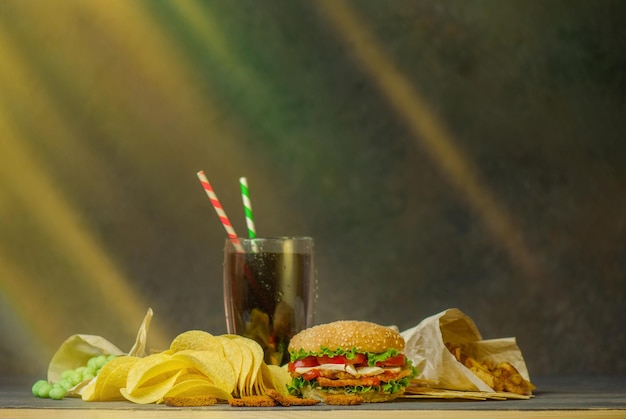 Koncepcja fast foodów i przekąsek Niezdrowe odżywianie hamburger frytki ziemniaczane i cola z dwiema papierowymi tubami