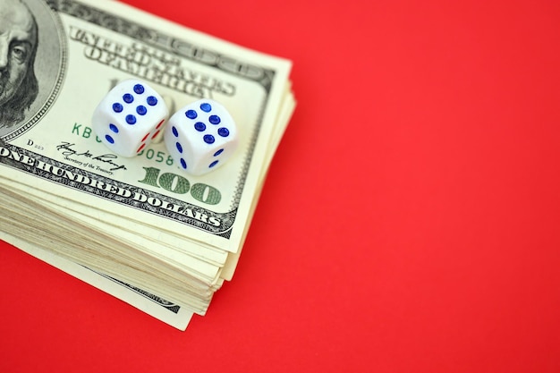 Koncepcja finansów i hazardu z pieniędzmi Zbliżenie na banknoty sto dolarów amerykańskich i dwie białe kostki na górze pokazujące liczby sześć
