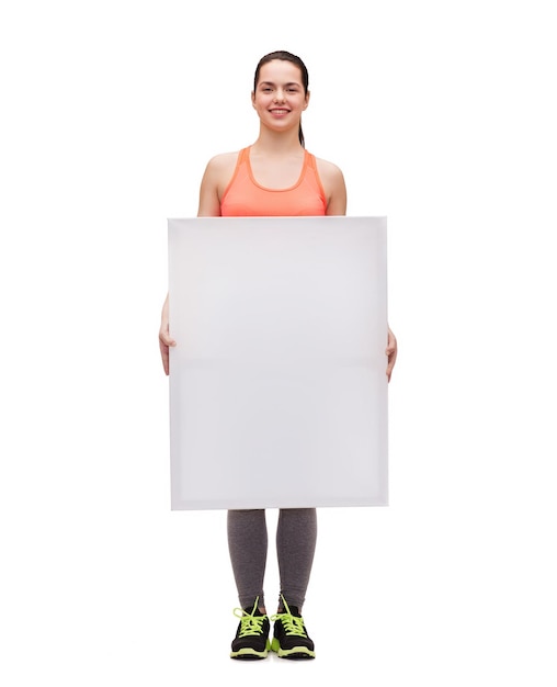 Zdjęcie koncepcja fitness i diety - uśmiechnięta nastolatka w stroju sportowym z białą pustą tablicą