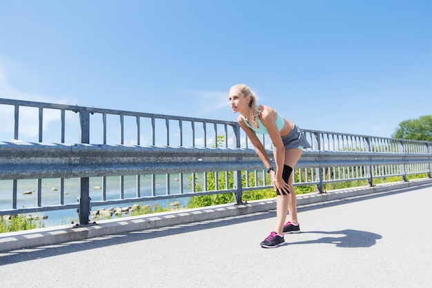 koncepcja fitness, sport, ćwiczenia i zdrowy styl życia - młoda kobieta z ortezą kolana na nodze na zewnątrz