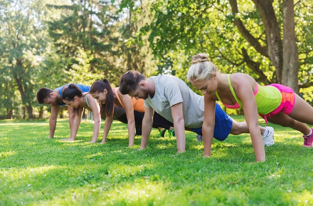 Koncepcja Fitness, Sportu, Przyjaźni I Zdrowego Stylu życia - Grupa Nastoletnich Przyjaciół Lub Sportowców ćwiczących I Robiących Pompki Na Obozie Startowym