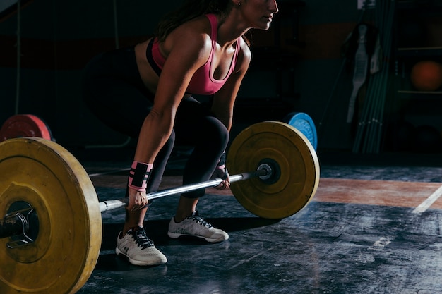 Koncepcja fitness z kobietą pracującą obecnie z barbell