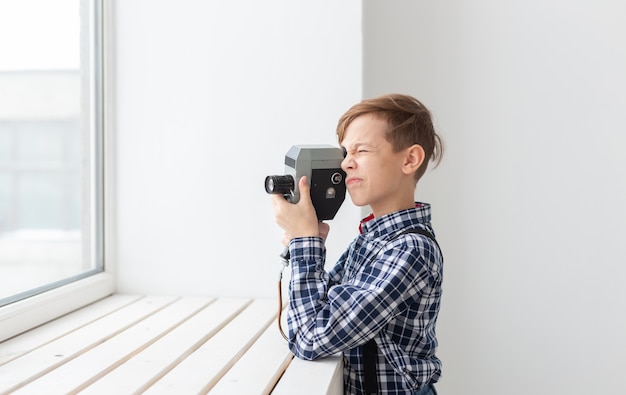 Koncepcja fotografa, dzieci i hobby - chłopiec trzyma stary aparat