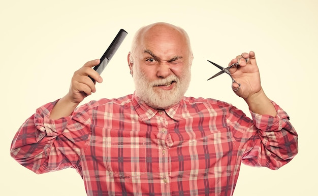 Koncepcja fryzjera Mężczyzna brodaty przystojny fryzjer fryzjer używa narzędzia do stylizacji brody Strzyżenie męskie Strzyżenie włosów Fryzjer używa profesjonalnego sprzętu Usługi fryzjerskie Fryzjer pracuje z ostrymi nożyczkami
