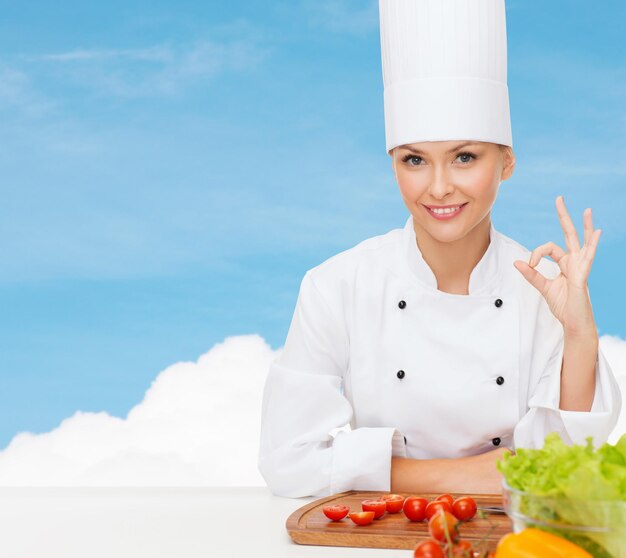 koncepcja gotowania i jedzenia - uśmiechnięta szefowa kuchni z warzywami pokazująca znak ok