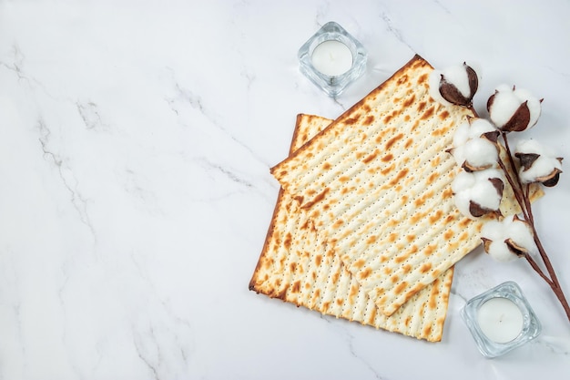 Koncepcja Happy Passover Chleb z macy i kwiaty bawełny na białym marmurze