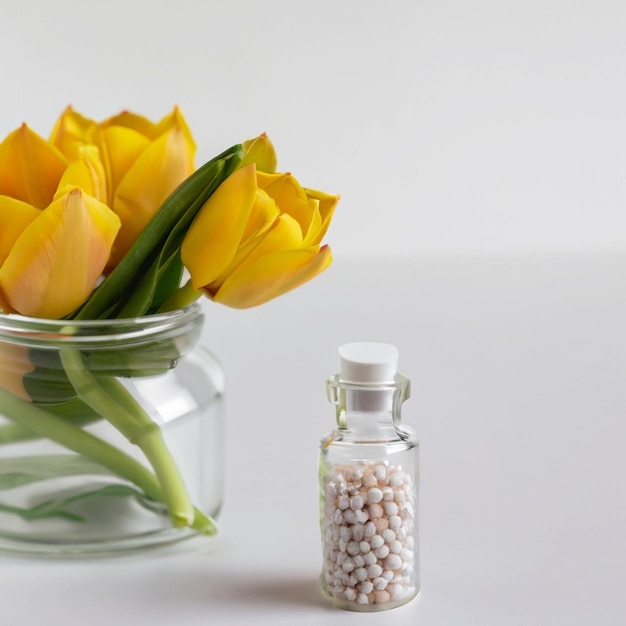 Koncepcja homeopatyczna Różanina w przezroczystej kolbie i ziarna homeopatyczne na białym tle