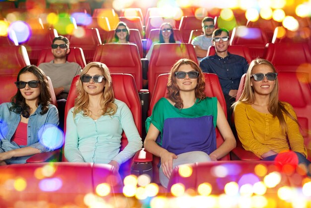 Zdjęcie koncepcja kina, technologii, rozrywki i ludzi - szczęśliwi przyjaciele w okularach 3d oglądający film w kinie