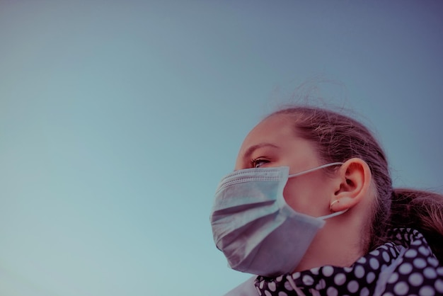 Koncepcja koronawirusa i zanieczyszczenia powietrza pm2.5. Mała dziewczynka nosi maskę do ochrony pm2.5. Więzienie dla dzieci w domu w celu ochrony wirusa koronowego. Objawy koronawirusa wuhan i epidemii wirusa.
