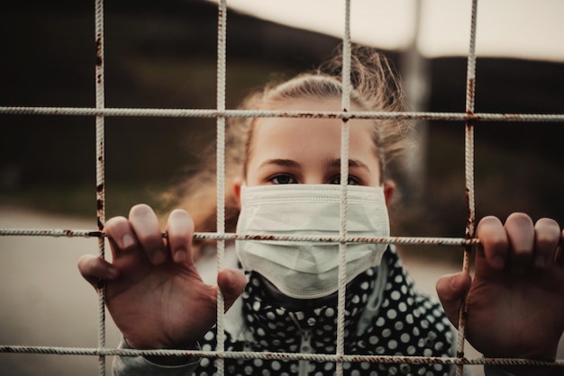 Koncepcja koronawirusa i zanieczyszczenia powietrza pm2.5. Mała dziewczynka nosi maskę do ochrony pm2.5. Więzienie dla dzieci w domu w celu ochrony wirusa koronowego. Objawy koronawirusa wuhan i epidemii wirusa.