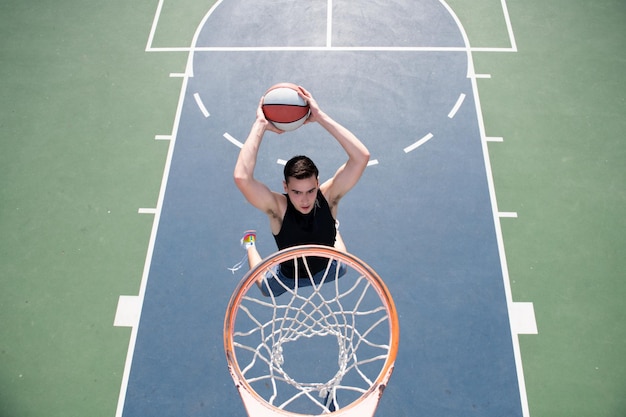 Koncepcja koszykówki Mężczyzna skaczący i wykonujący wsad grający w koszykówkę streetball Miejski autentyczny