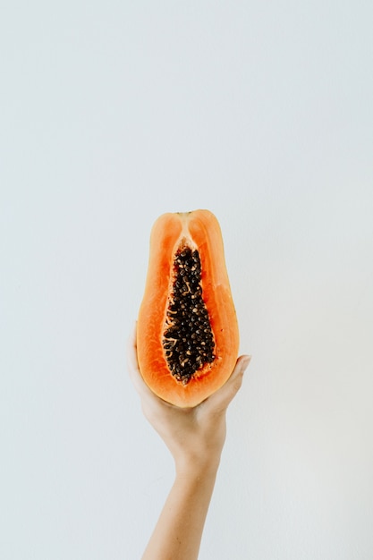 Koncepcja lato i podróże. Młoda kobieta ręka trzyma egzotycznych owoców tropikalnej papai pomarańczy