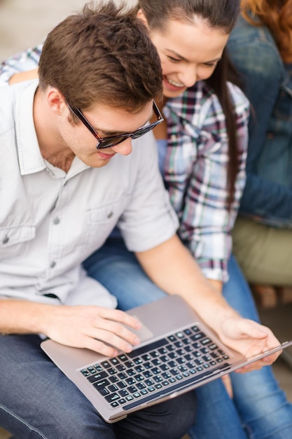 koncepcja lato, internet, edukacja, kampus i młodzież - studenci lub nastolatki spędzają czas z laptopem