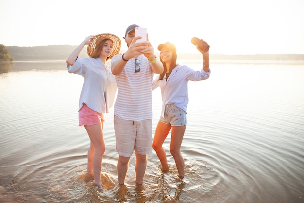 Koncepcja lato, wakacje, wakacje i szczęście - grupa przyjaciół biorących selfie z smartphone.