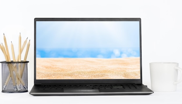 Koncepcja letnich wakacji Laptop na biurku z obrazem morza