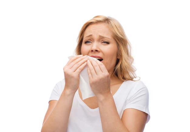 koncepcja ludzi, opieki zdrowotnej, nieżytu nosa, przeziębienia i alergii - nieszczęśliwa kobieta z kichaniem papierowej serwetki