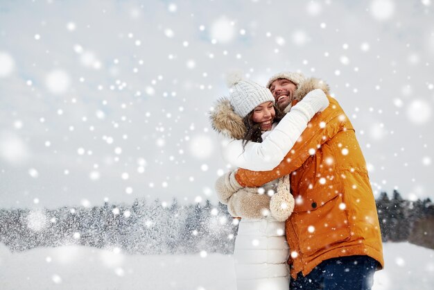koncepcja ludzi, pory roku, miłości i wypoczynku - szczęśliwa para przytulająca się zimą na świeżym powietrzu