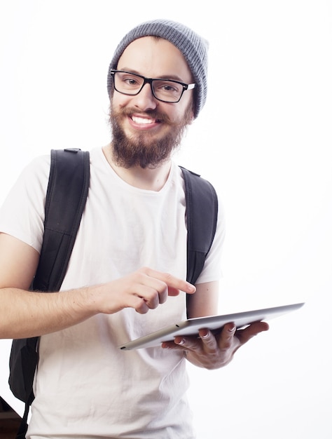 Koncepcja ludzie, podróże, turystyka i technologia - szczęśliwy młody brodaty mężczyzna w okularach z plecakiem i tabletem na białym tle. Styl Hipster. Pozytywne emocje.