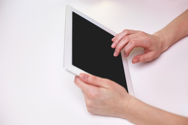 koncepcja ludzie, technologia i internet - zbliżenie kobiecych rąk z komputerem typu tablet przy stole