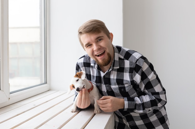 Koncepcja ludzie, zwierzęta domowe i pies - bliska portret mężczyzny trzymającego ładny szczeniak jack russell terrier.