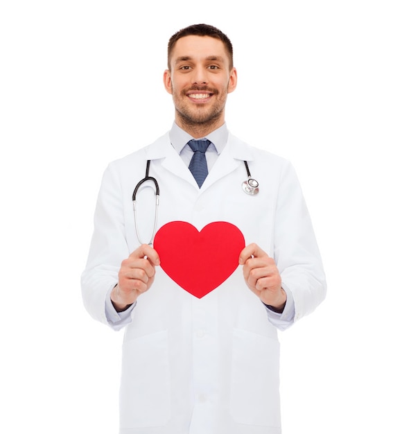 koncepcja medycyny, zawodu i opieki zdrowotnej - uśmiechnięty mężczyzna lekarz z czerwonym sercem i stetoskopem