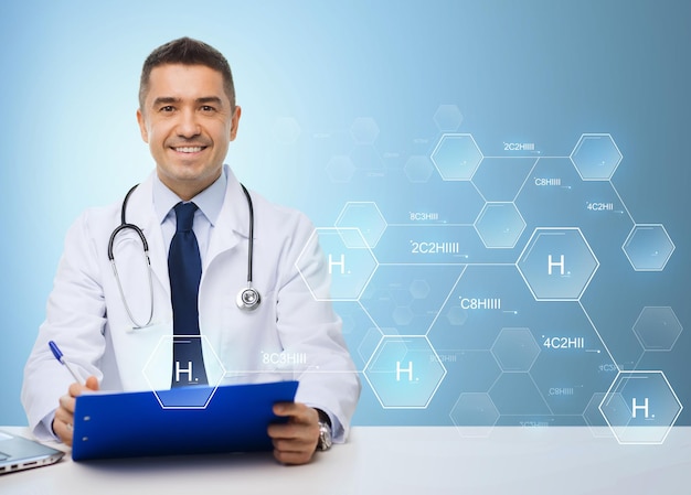 koncepcja medycyny, zawodu, technologii i ludzi - szczęśliwy mężczyzna lekarz ze schowkiem i stetoskopem na niebieskim tle z wzorem chemicznym wodoru
