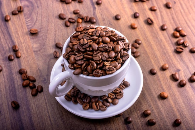 Koncepcja międzynarodowego dnia kawy Miska przepełniona ziarnami kawy na drewnianym stole