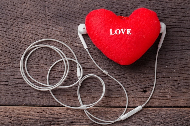Zdjęcie koncepcja miłośnika muzyki, serce miłości i słuchawka na drewnianym tle
