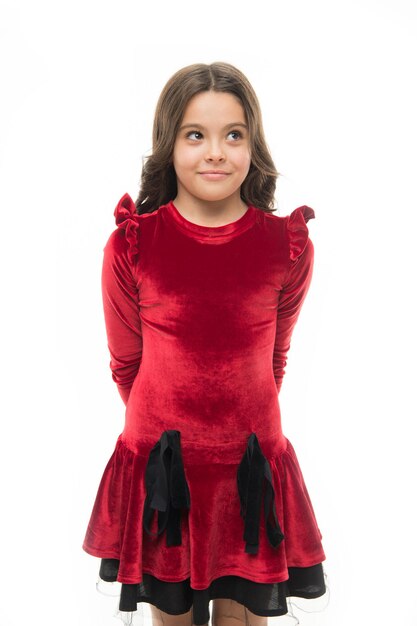 Koncepcja mody Kid urocza uśmiechnięta pozuje w czerwonej aksamitnej sukience Moda dziecięca Dziewczyna śliczna dziecko ubierz aksamitną sukienkę Aksamitna sukienka idealna do wyboru na każdą okazję Czuj się tak modnie w eleganckich ubraniach