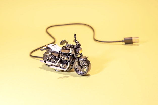 Koncepcja motocykla elektrycznego z żółtym tłem przewodu ładującego