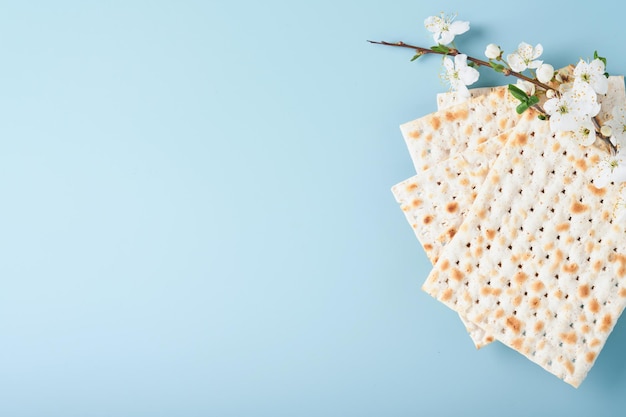 Koncepcja obchodów Paschy Matzah czerwone wino koszerne orzech i wiosenna piękna gałąź kwitnącej wiśni lub jabłka Tradycyjny żydowski chleb na jasnoniebieskim tle Pesach Żydowskie święto