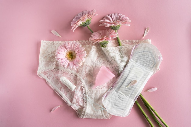 Koncepcja okresu menstruacyjnego Higieniczna biała podkładka dla kobiet Kubek menstruacyjny i tampon z różowymi kwiatami Ochrona menstruacji Zdrowie kobiet