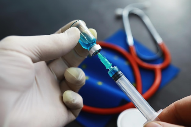 Koncepcja opieki zdrowotnej Flaga UE i stetoskop na szarym tle Szczepienia i epidemia