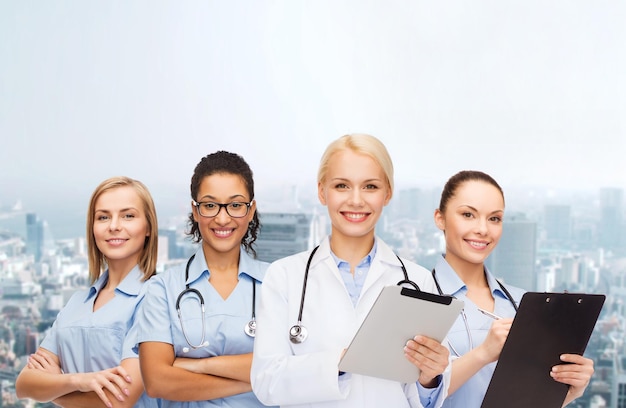 Zdjęcie koncepcja opieki zdrowotnej i medycyny - uśmiechnięta lekarka i pielęgniarki z komputerem typu tablet