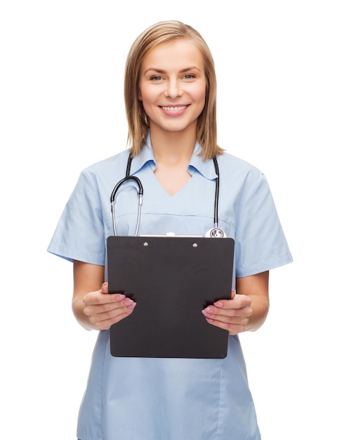 koncepcja opieki zdrowotnej i medycyny - uśmiechnięta lekarka lub pielęgniarka ze schowkiem i stetoskopem