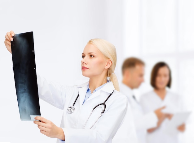 koncepcja opieki zdrowotnej, medycyny i radiologii - poważna lekarka patrząca na prześwietlenie