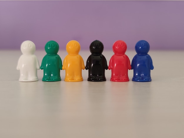 Zdjęcie koncepcja - partnerstwo, współpraca, figurki do gry lub pionki w sytuacji biznesowej. kolorowe żetony gry stołowej w formie małych mężczyzn