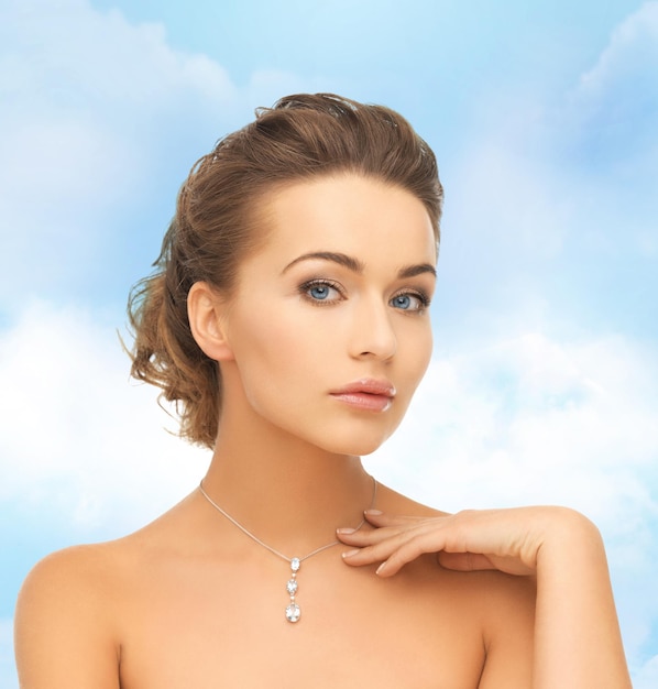 koncepcja piękna i biżuterii - kobieta nosząca błyszczący diamentowy wisiorek