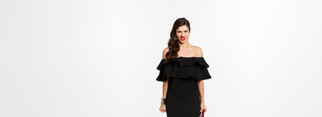 Zdjęcie koncepcja piękna i mody pełnej długości wściekłej kobiety w czarnej imprezowej sukience i szpilkach ekspresowym di