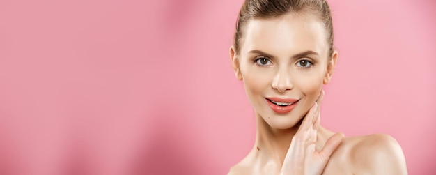 Koncepcja piękna piękna kobieta z czystą, świeżą skórą z bliska na różowym studio do pielęgnacji skóry kosmetyczna