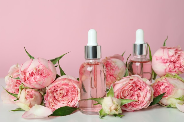 Koncepcja pielęgnacji skóry z olejkiem różanym na różowym tle