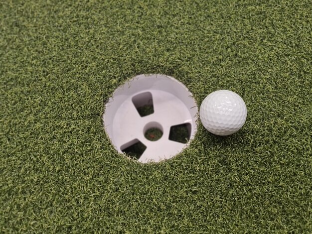 Zdjęcie koncepcja piłki golfowej i dziury golfowej na zielonym trawniku