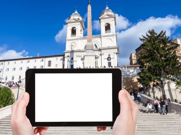 koncepcja podróży - fotografie turystyczne Kościół Santissima Trinita dei Monti i Schody Hiszpańskie w Rzymie na tablecie z wyciętym ekranem z pustym miejscem na reklamę we Włoszech
