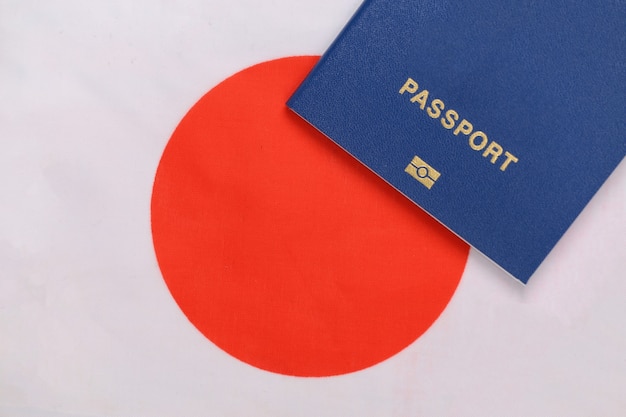 Koncepcja podróży. Paszport na tle japońskiej flagi