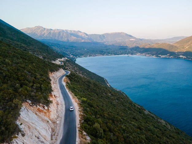 Koncepcja podróży samochodem poruszającym się po drogach w górach z widokiem na brzeg morza