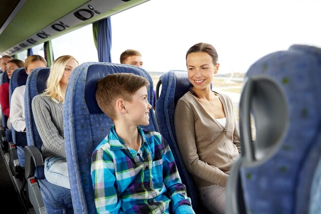 Zdjęcie koncepcja podróży, turystyki, rodziny, technologii i ludzi - szczęśliwa matka i syn jadący autobusem turystycznym