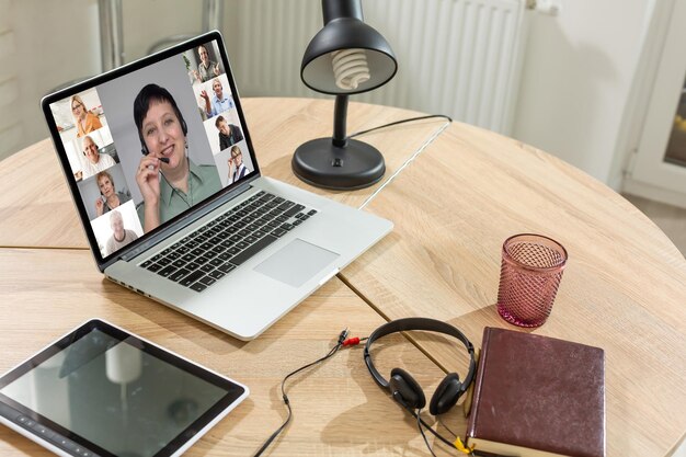 Koncepcja połączenia czatu wideo grupy znajomych. Laptop na stole, wnętrze domu.